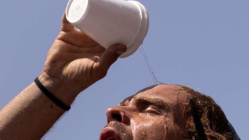 FILE PHOTO: Man pours water atop head during heat wave in Houston