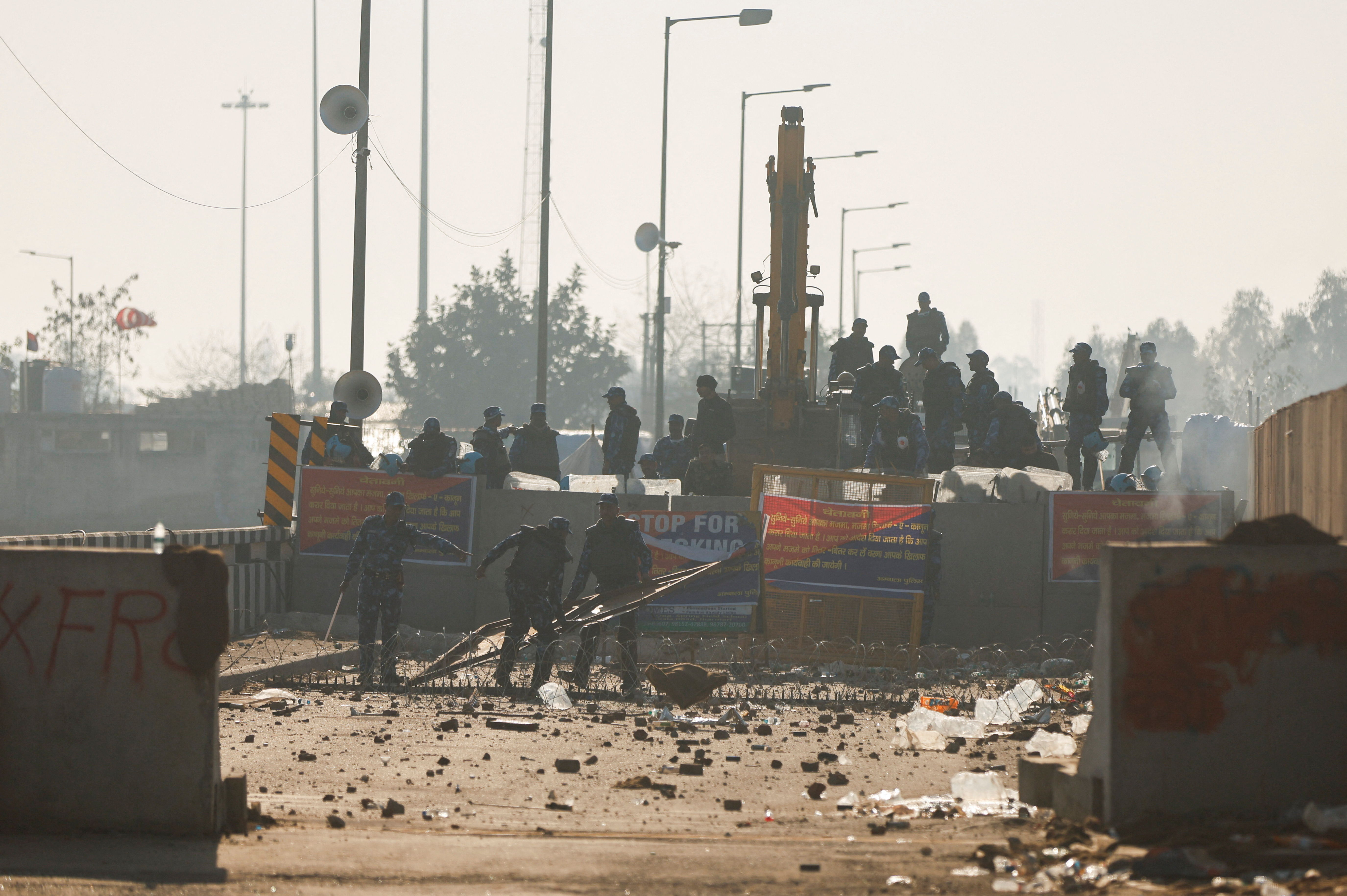 Police move a makeshift barricade at the site of a protest as farmers march towards New Delhi to push for better crop prices promised to them in 2021, at Shambhu Barrier