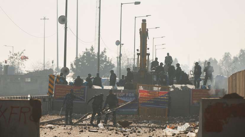 Police move a makeshift barricade at the site of a protest as farmers march towards New Delhi to push for better crop prices promised to them in 2021, at Shambhu Barrier