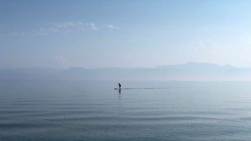 A man paddles in the Ionian Sea near the island of Corfu