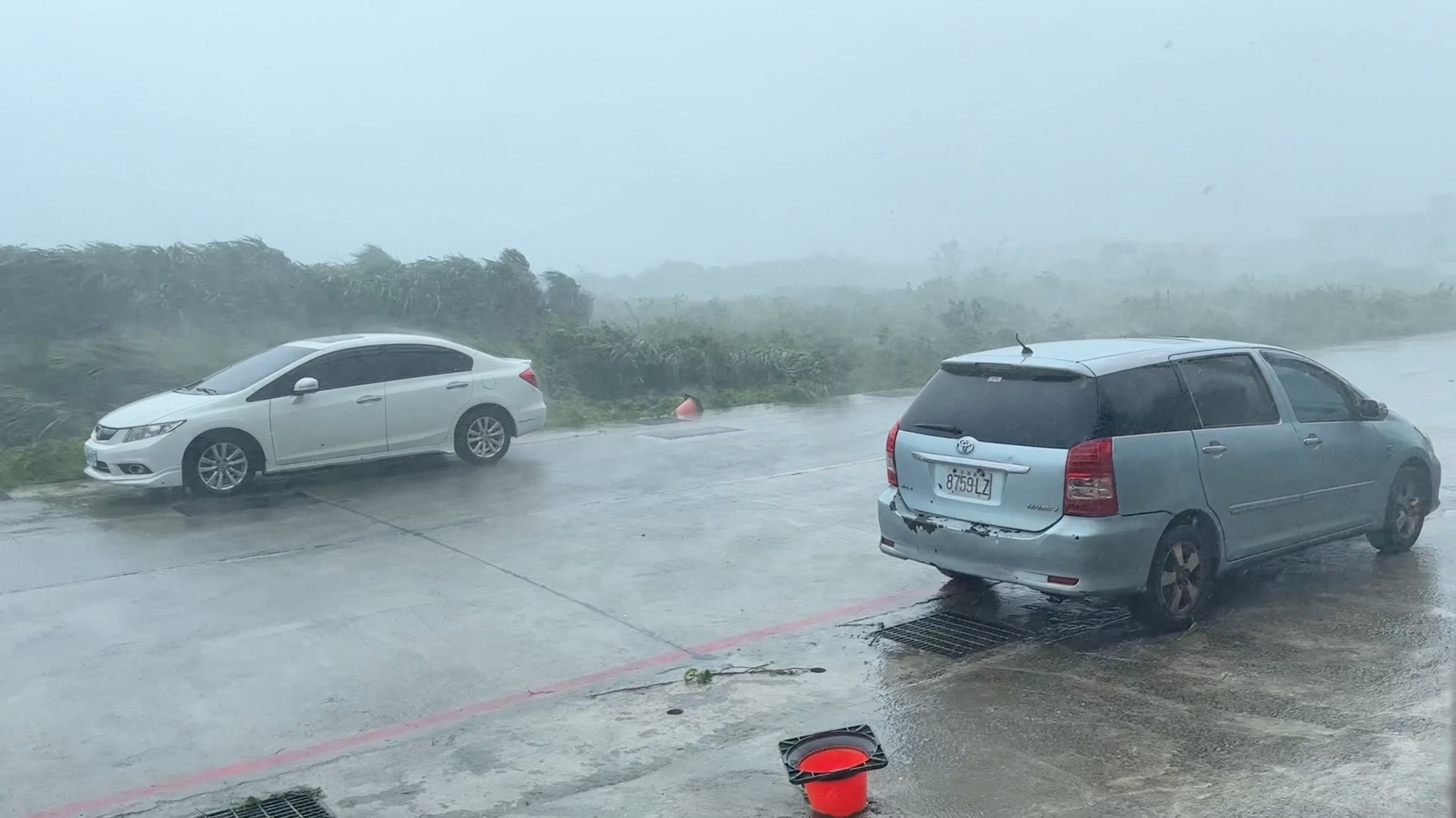 Vehicles stand on a road during a storm, in Green Island