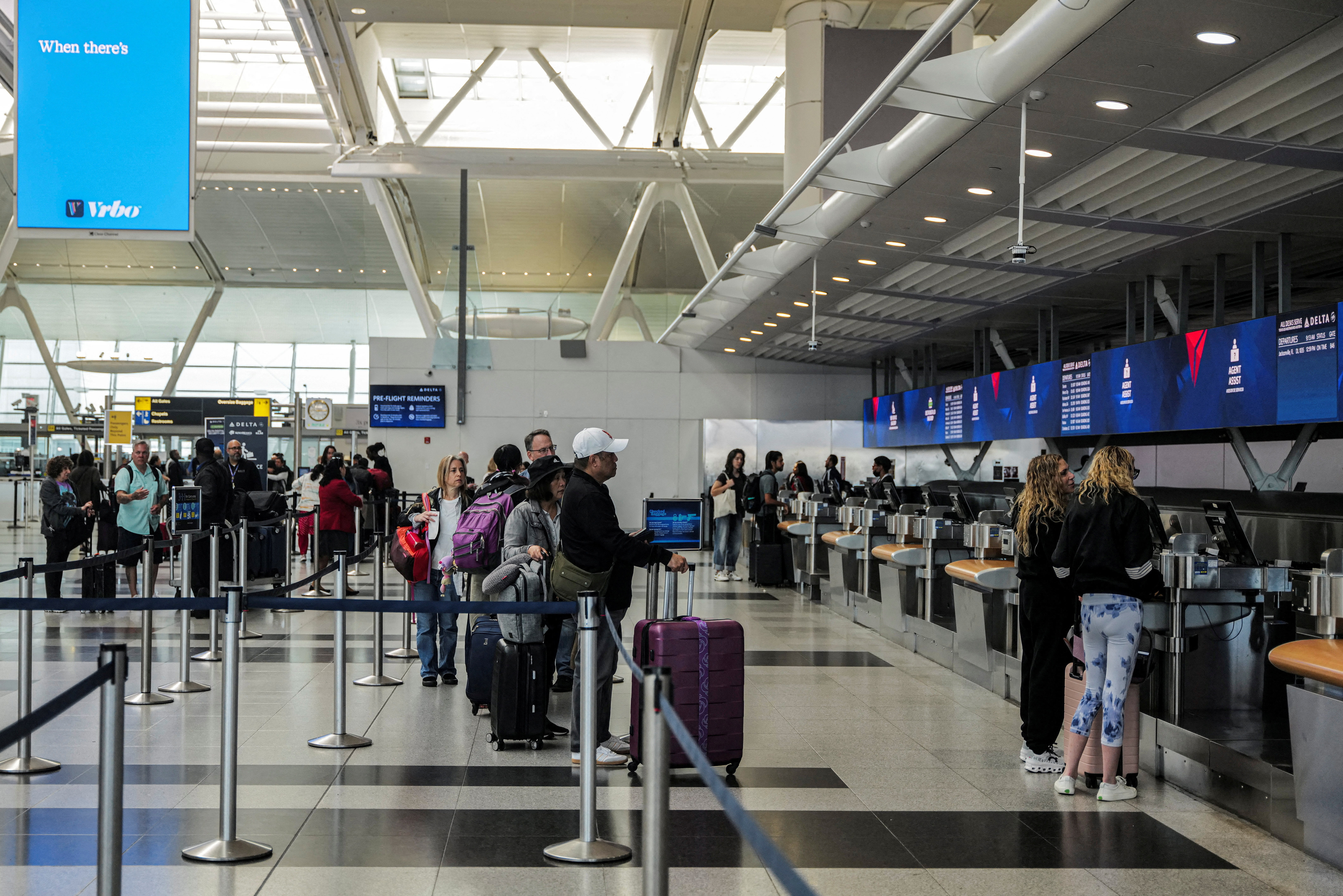 FILE PHOTO: Travellers are seen at the Delta Airlines check-in area at John F. Kennedy International Airport (JFK) in New York City