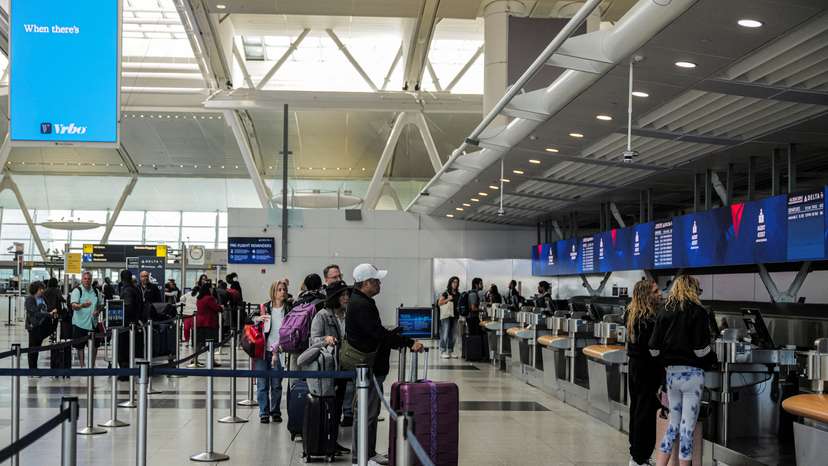 FILE PHOTO: Travellers are seen at the Delta Airlines check-in area at John F. Kennedy International Airport (JFK) in New York City