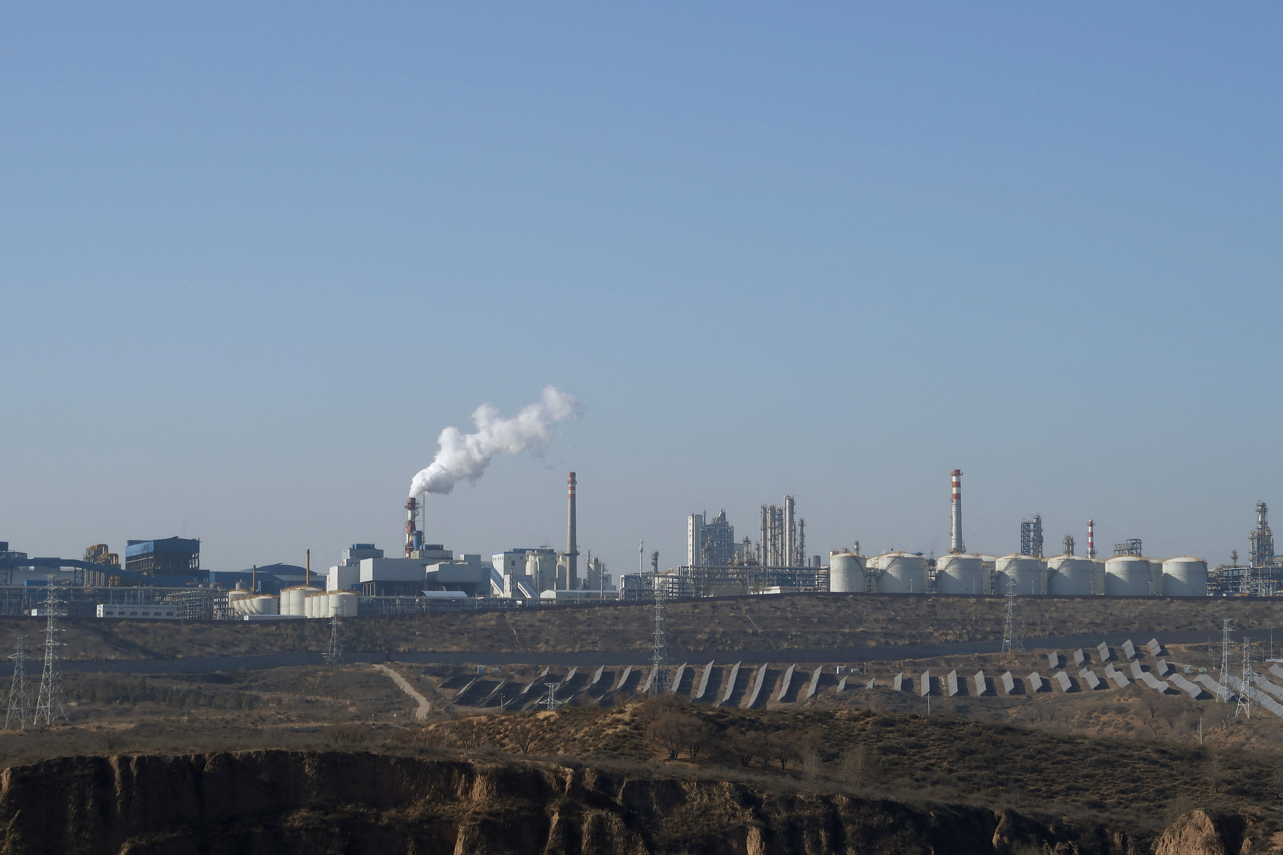 FILE PHOTO: Solar panels lie in front of factories at Jinjie Industrial Park in Shenmu