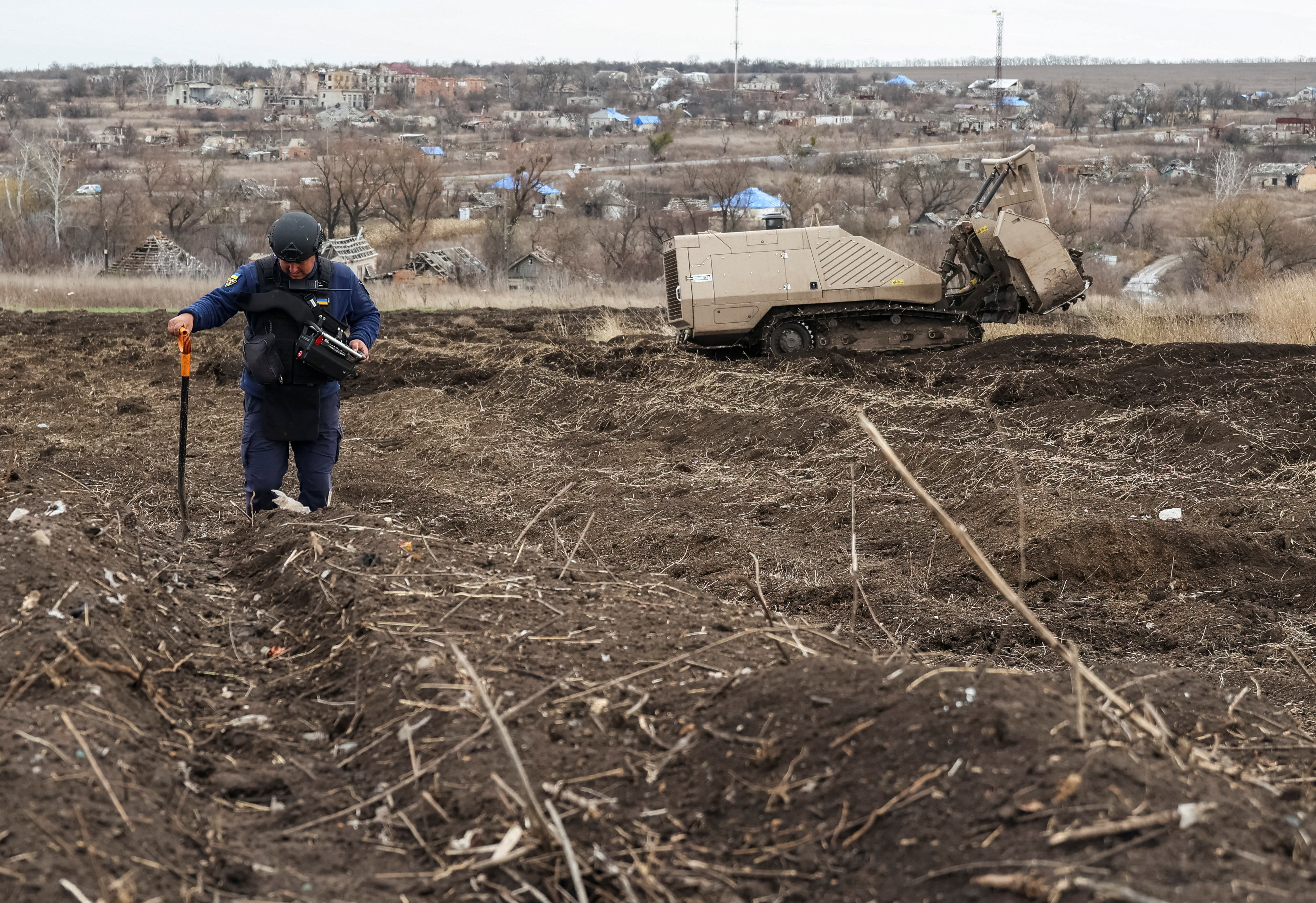 State Emergency Service deminer uses a remote-controlled de-mining vehicle GCS 200 to work on a field near the village of Kamianka