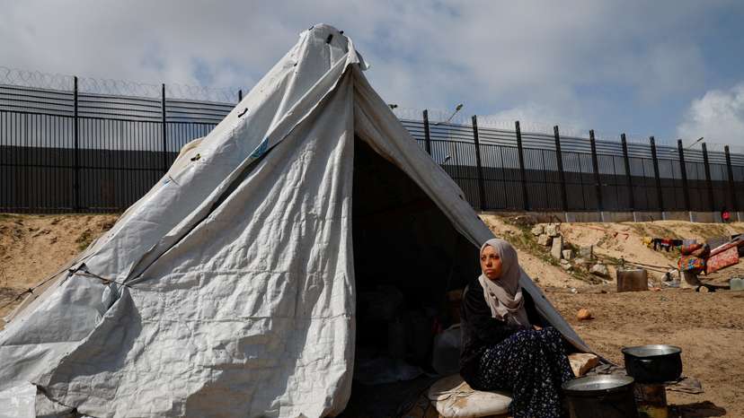 Displaced Palestinian women, who fled their houses due to Israeli strikes shelter in a tent camp, in Rafah