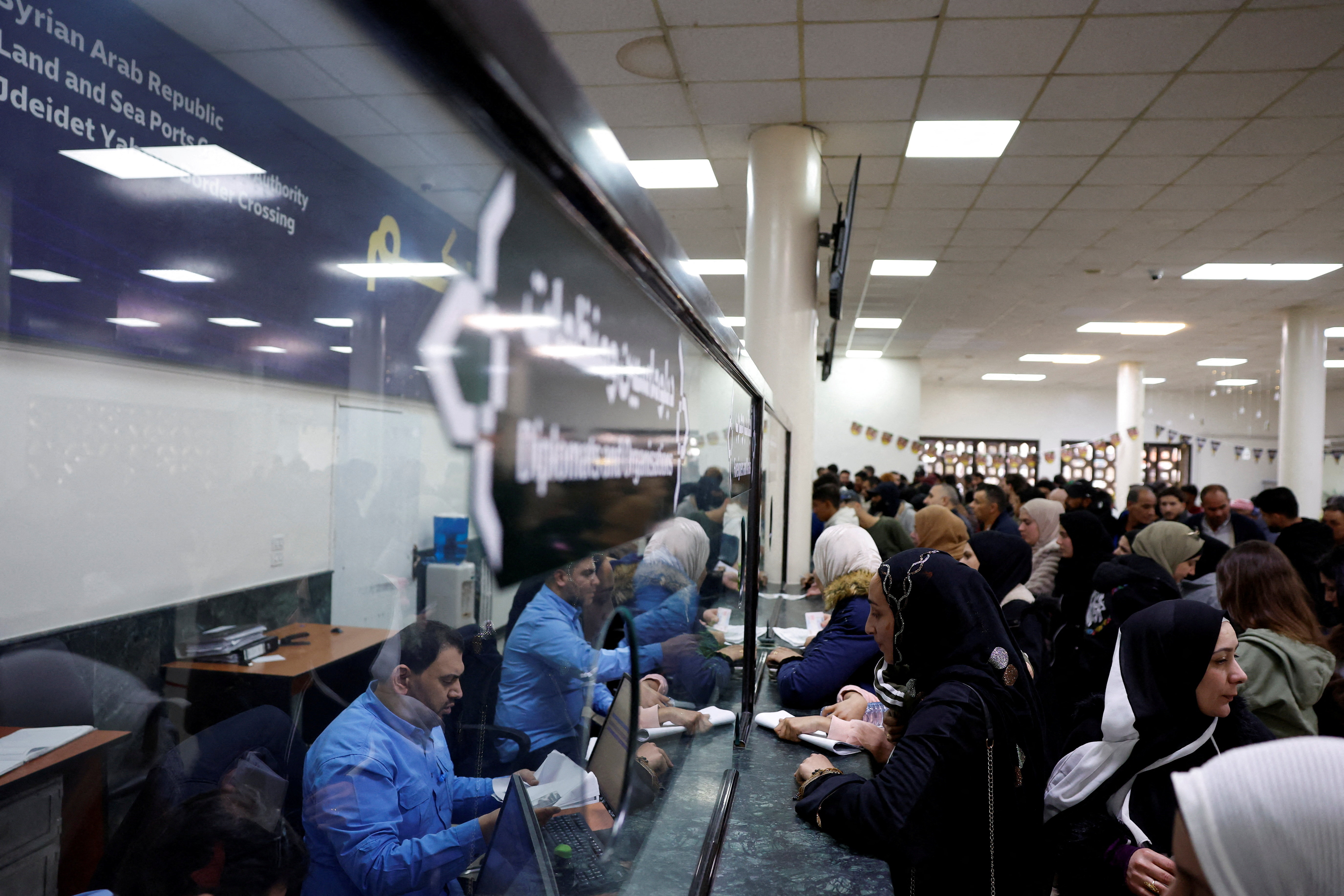 Syrians living in Lebanon wait at the Ministry of Interior Immigration and Passports Department, at the Syrian-Lebanese border, in Jdeidet Yabous