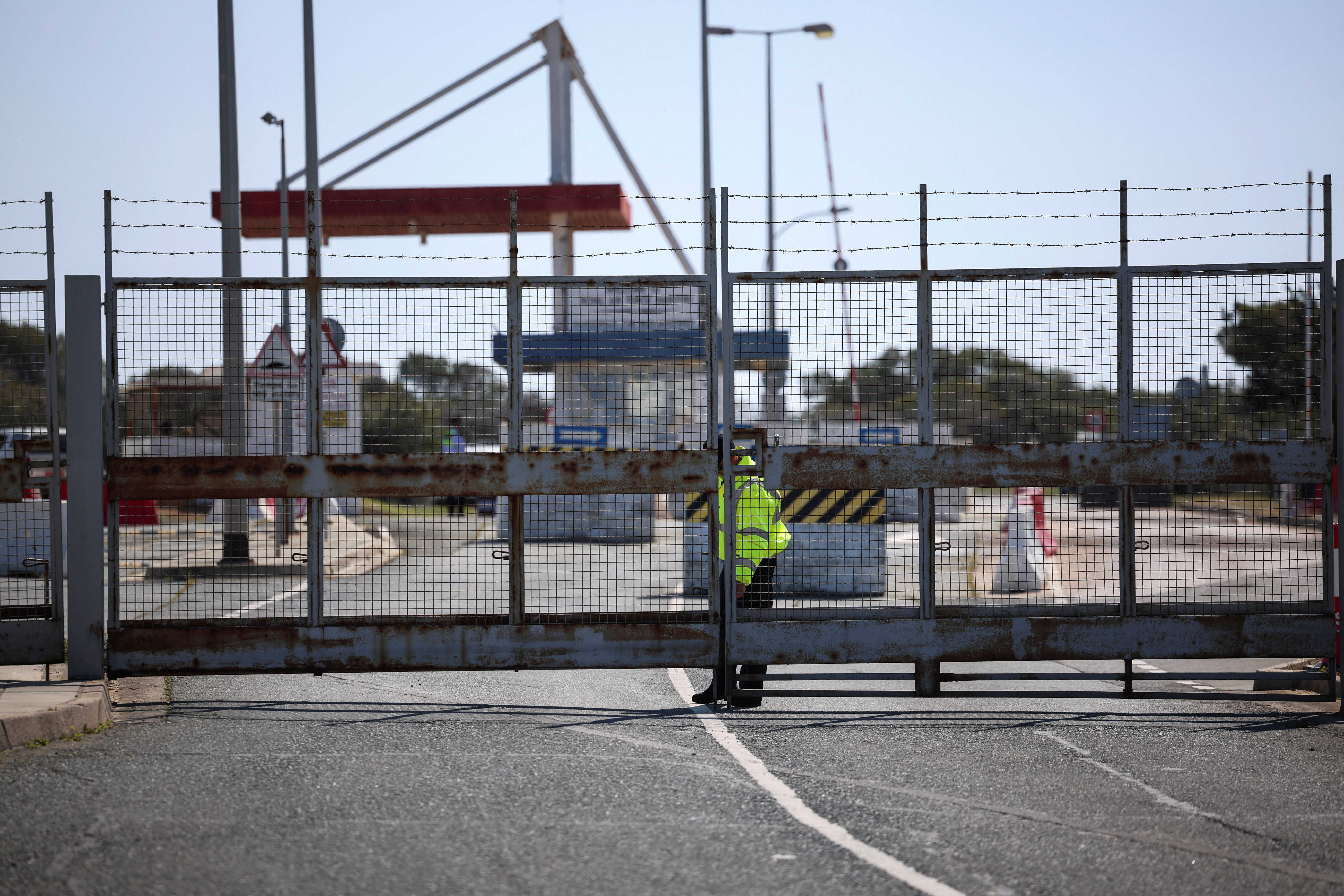 A police officer closes the entrance of RAF Akrotiri, a British sovereign base in Cyprus, which was hit by an unmanned drone overnight, causing limited damage,