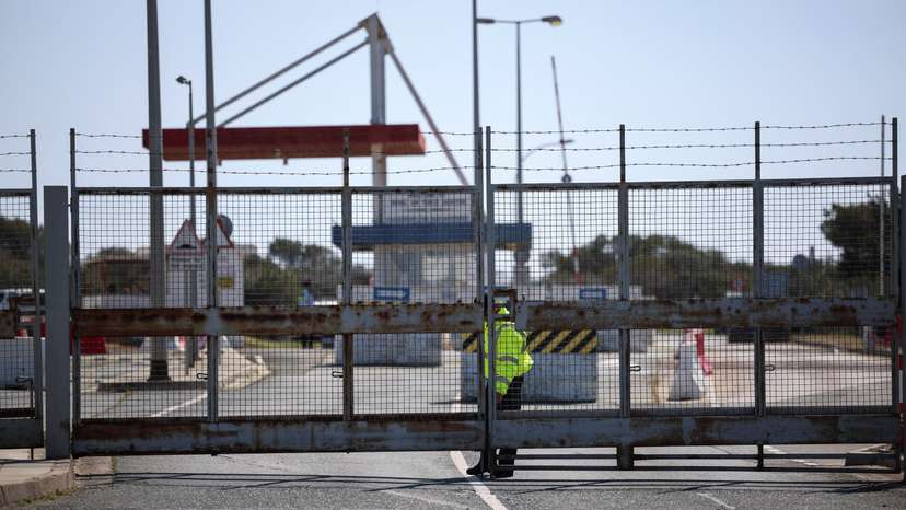 A police officer closes the entrance of RAF Akrotiri, a British sovereign base in Cyprus, which was hit by an unmanned drone overnight, causing limited damage,