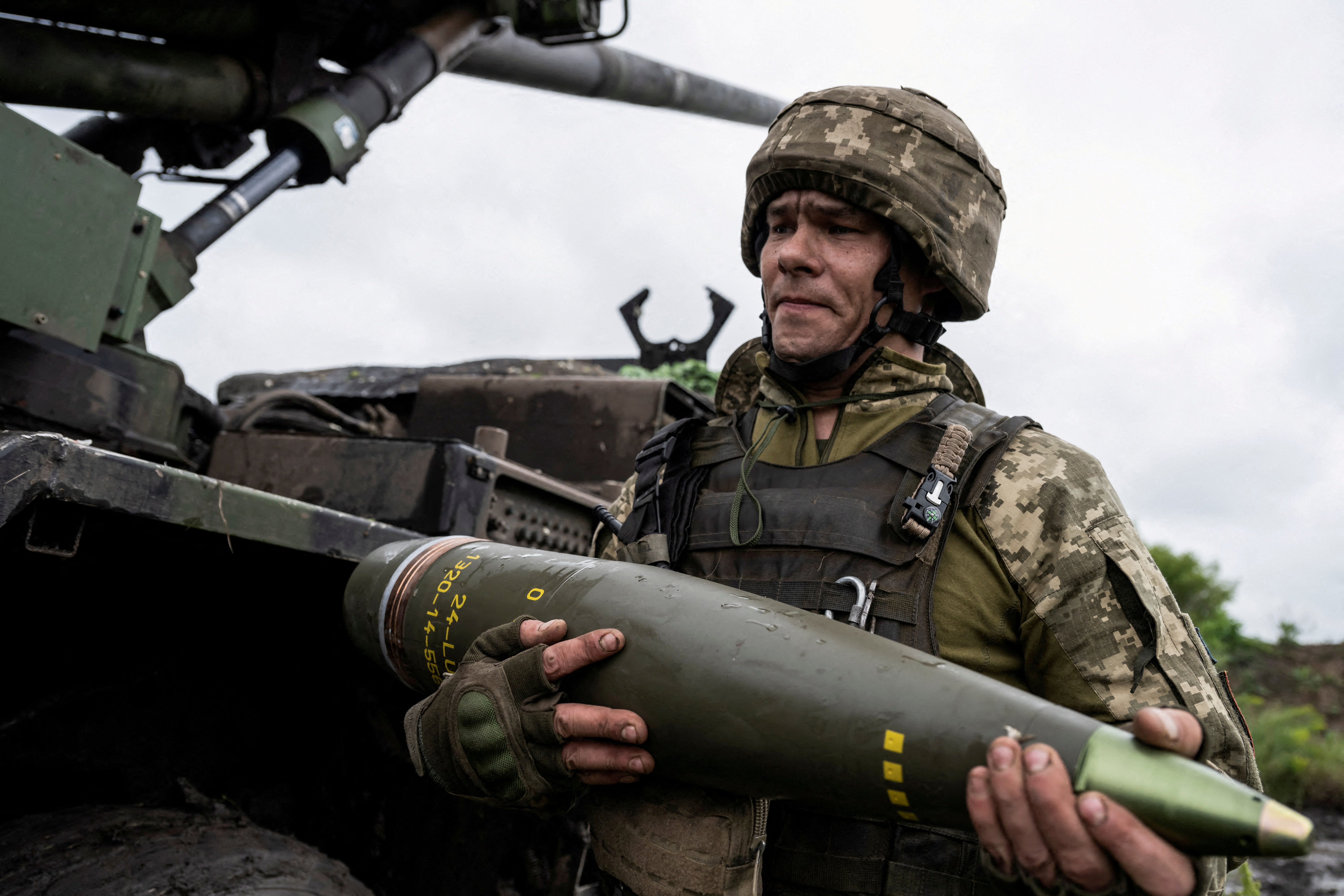 FILE PHOTO: Ukrainian service member carries a shell for a Caesar self-propelled howitzer before firing towards Russian troops near Avdiivka
