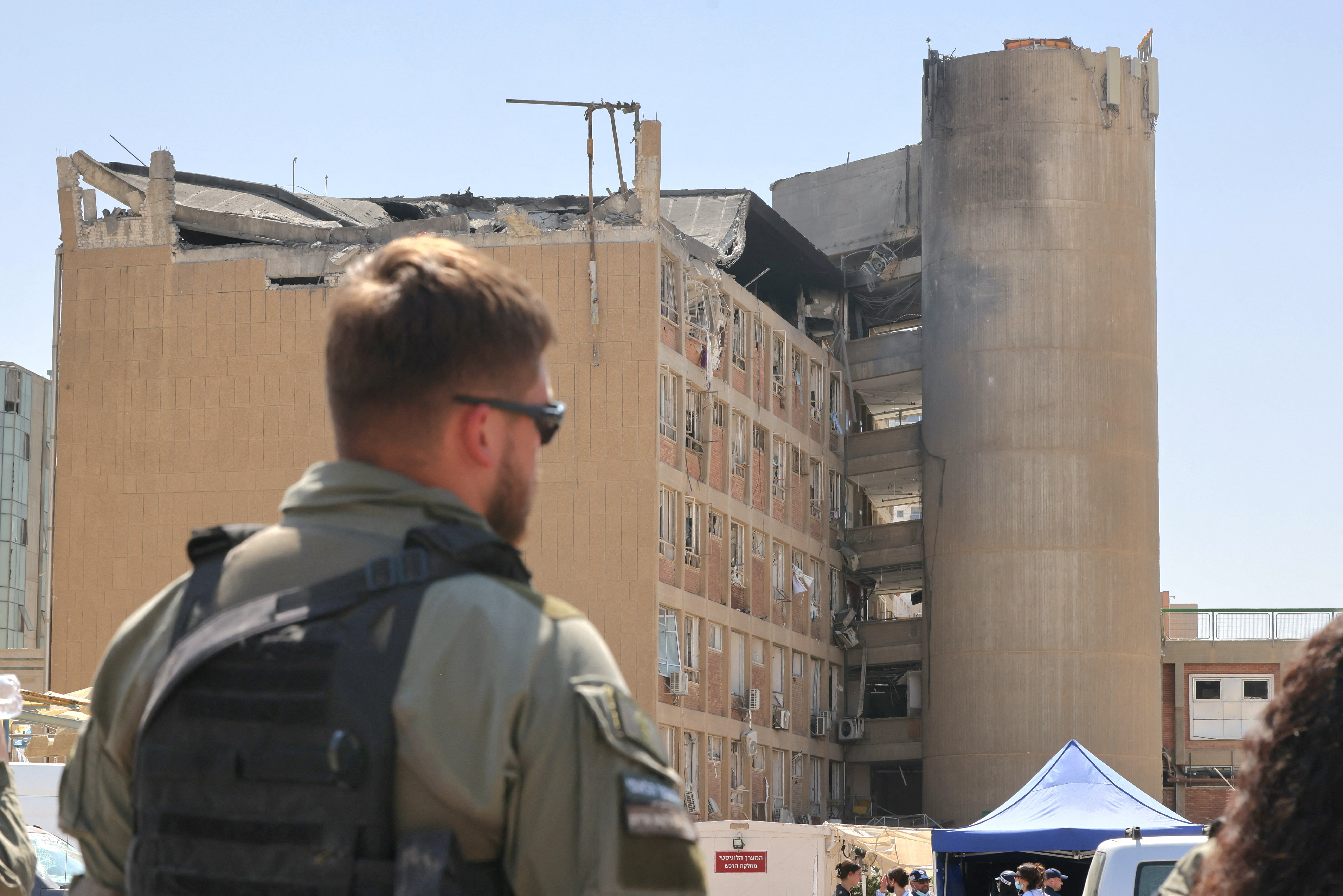 A member of the Israeli security forces walks near the Soroka Medical Center, after it was hit by a missile fired from Iran, in Beersheba