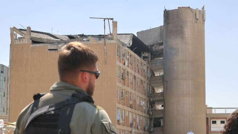 A member of the Israeli security forces walks near the Soroka Medical Center, after it was hit by a missile fired from Iran, in Beersheba
