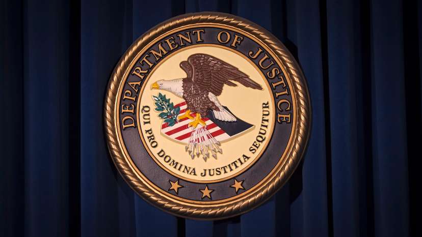 The DOJ logo is pictured on a wall after a news conference in New York