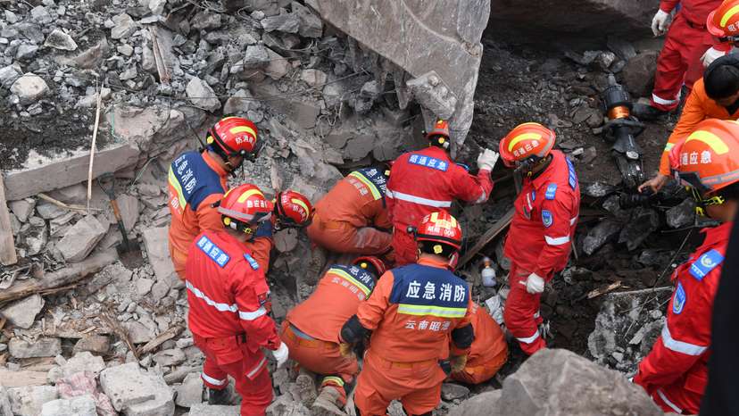 Rescue workers search for survivors in the debris after a landslide hit Zhenxiong County, in Zhaotong
