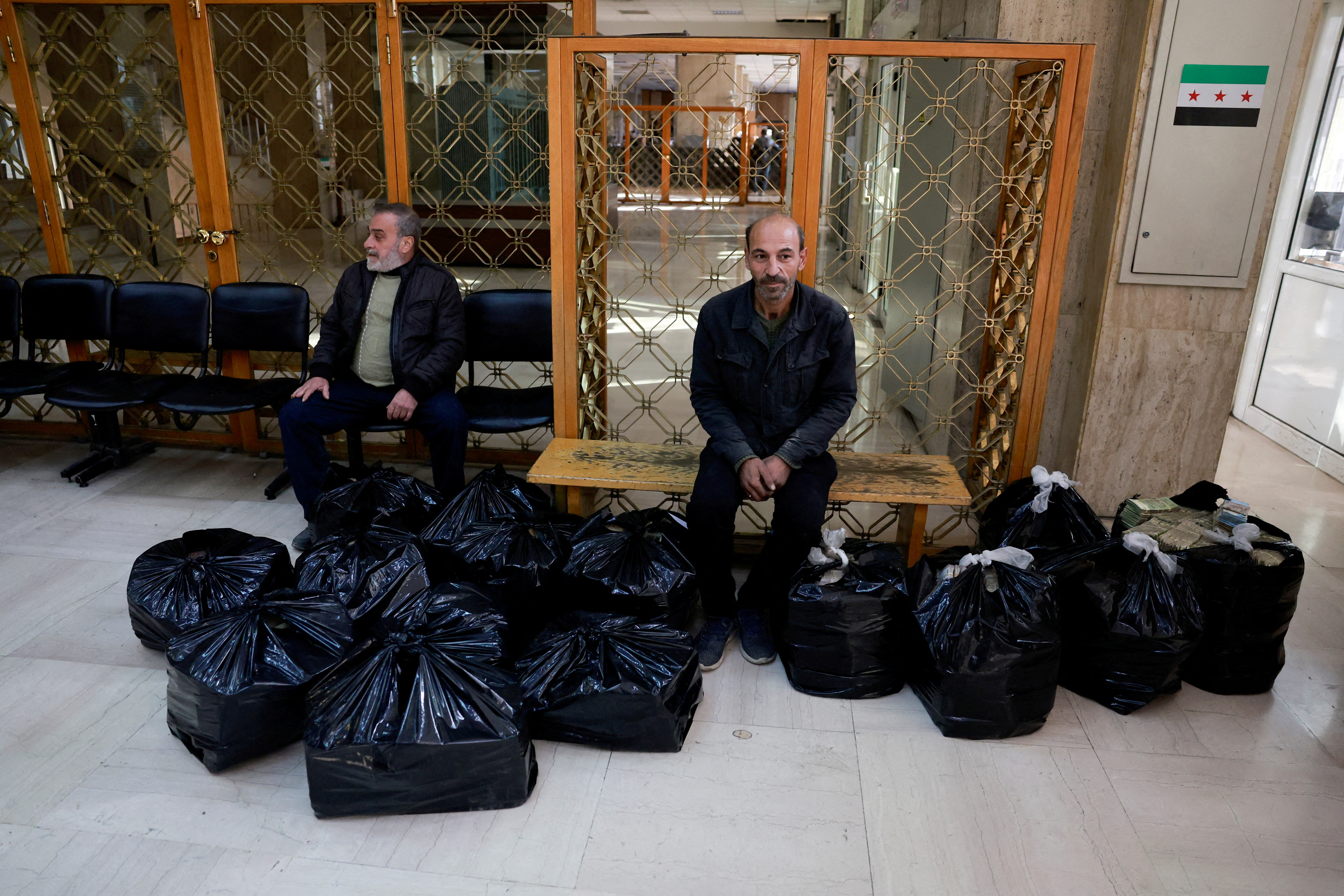 FILE PHOTO: Workers move money to Syrian central bank in Damascus
