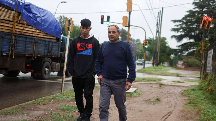 Bricklayer Jose Luis Rodriguez walks with his son to the bus stop on the outskirts of Buenos Aires
