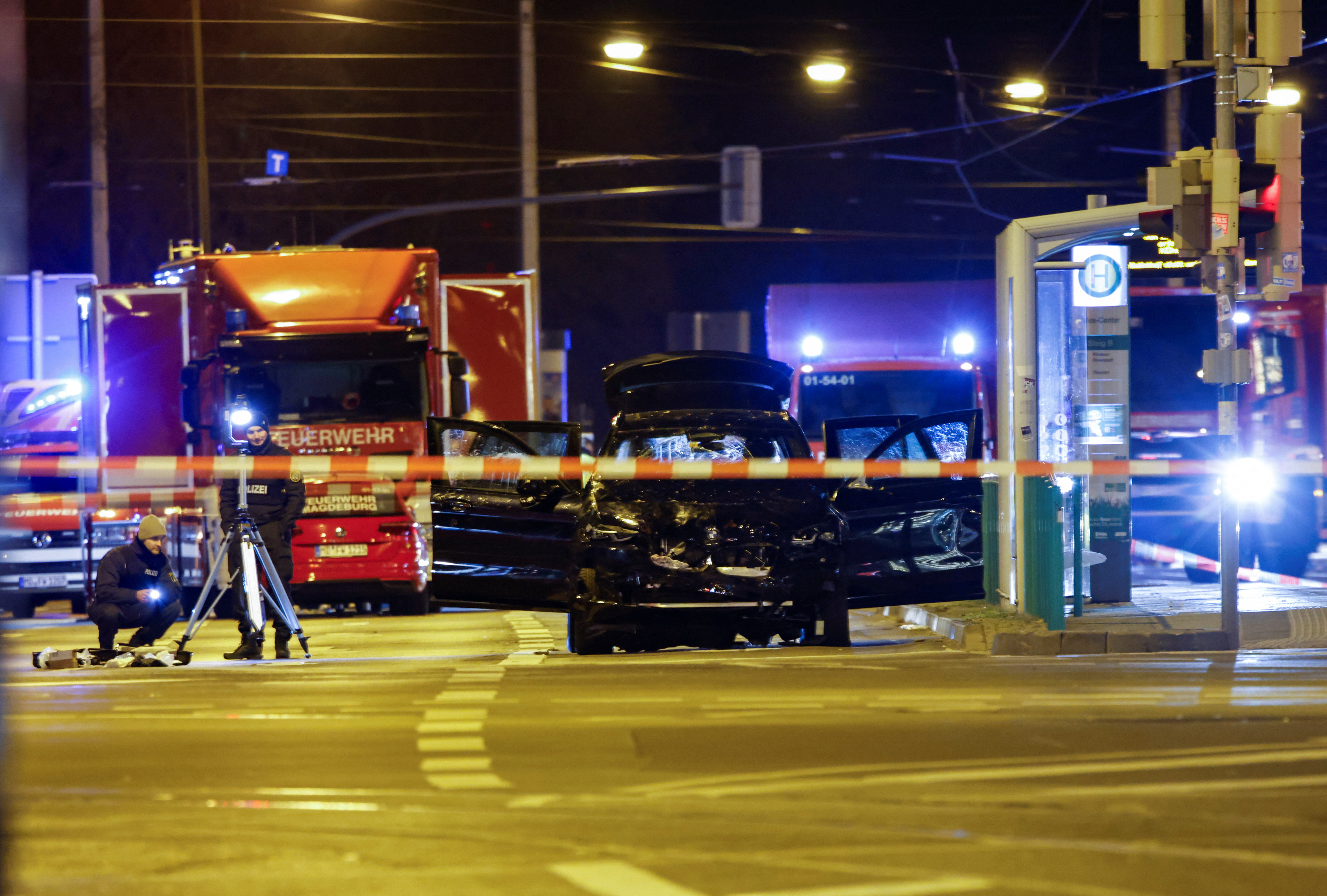Emergency personnel stand next to a damaged car that drove into a group of people, according to local media, in Magdeburg