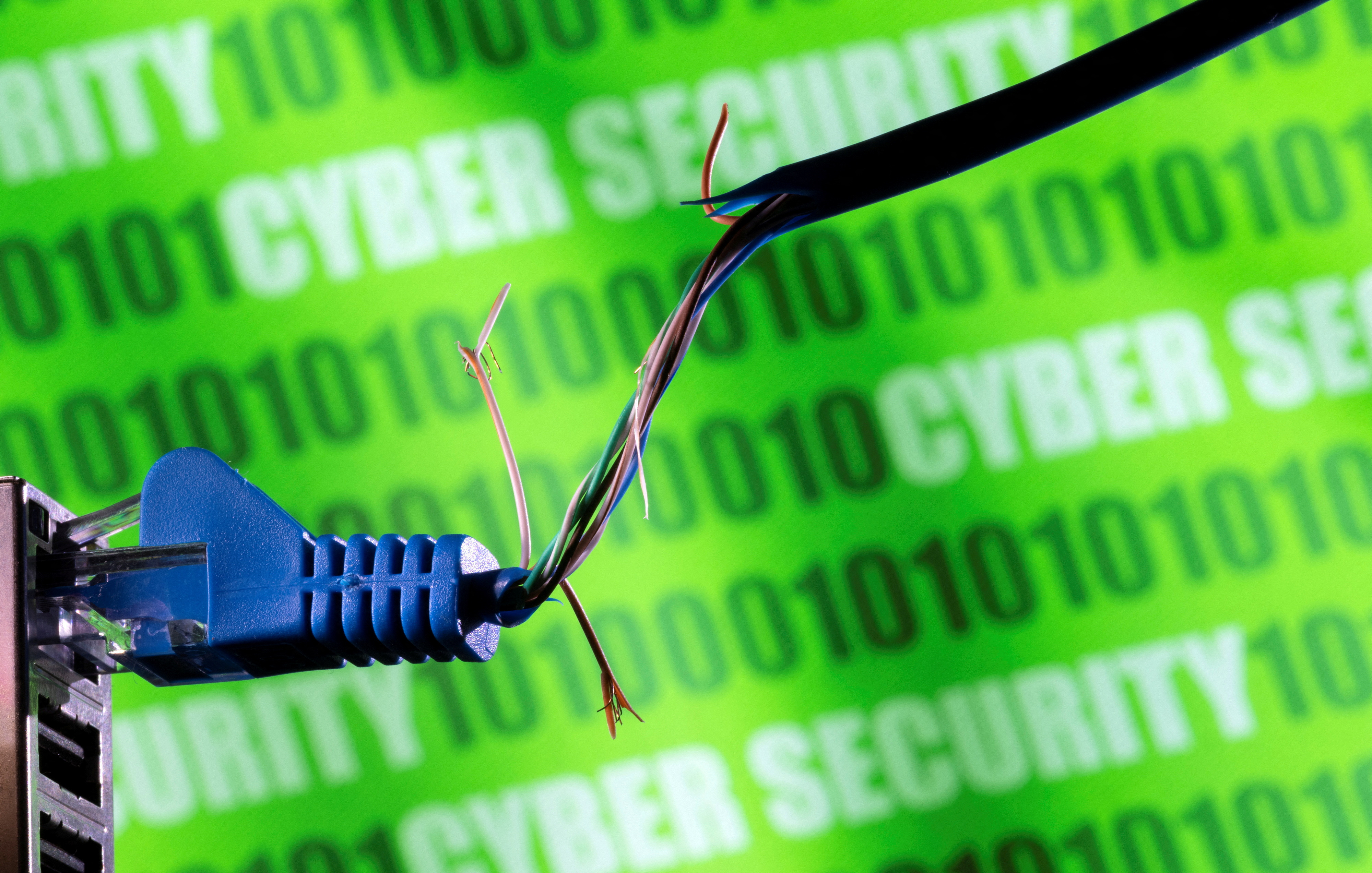 FILE PHOTO: Illustration shows broken Ethernet cable, binary code and words "cyber security\