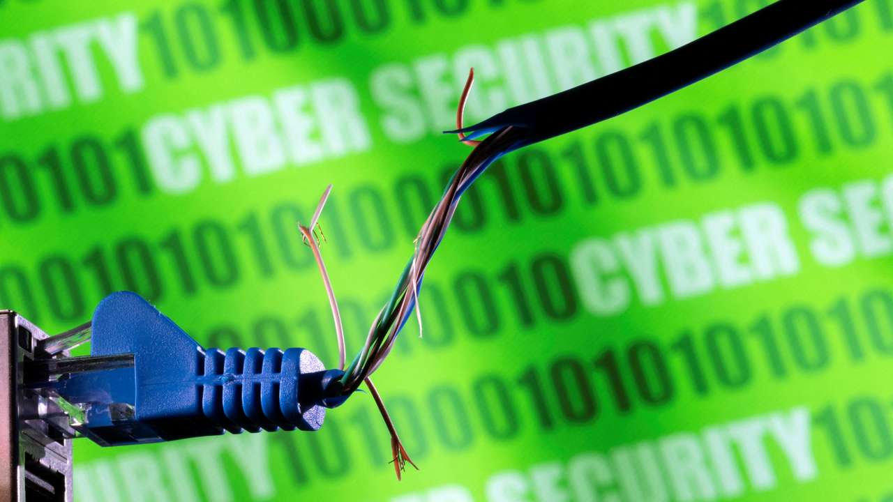 FILE PHOTO: Illustration shows broken Ethernet cable, binary code and words "cyber security\