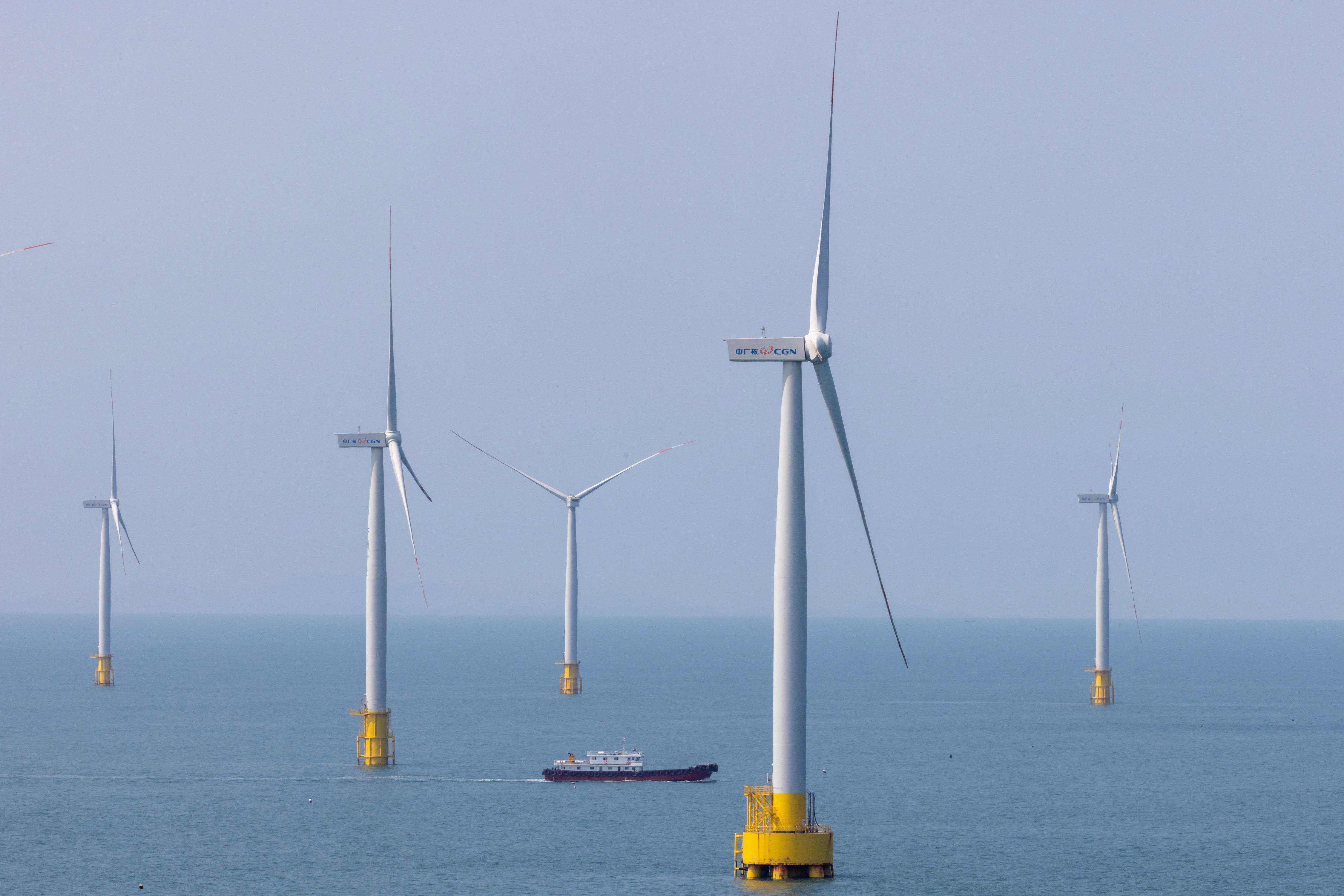 FILE PHOTO: A ship sails between wind turbines in the Taiwan strait off the coast of Pingtan Island