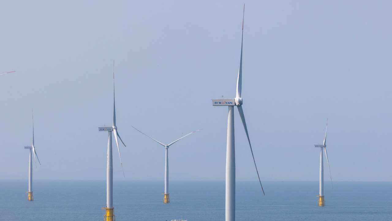 FILE PHOTO: A ship sails between wind turbines in the Taiwan strait off the coast of Pingtan Island