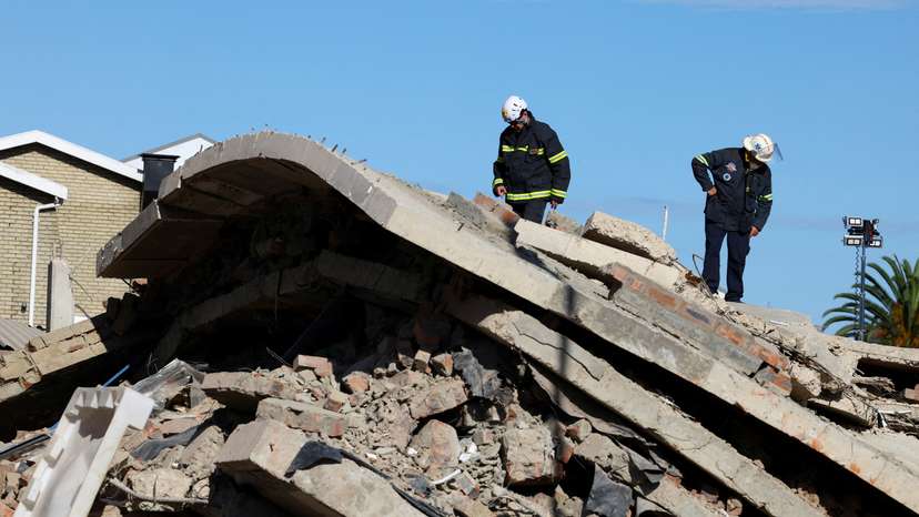 FILE PHOTO: Rescuers work to rescue construction workers trapped under a building that collapsed in George