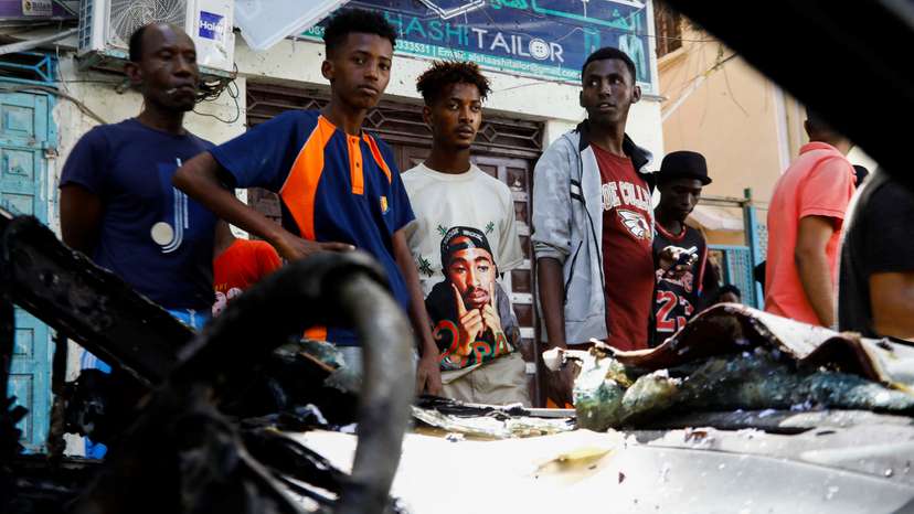 Somalis look at the wreckage of a vehicle destroyed at the scene of a suicide bomb blast in the Hamar Weyne district of Mogadishu