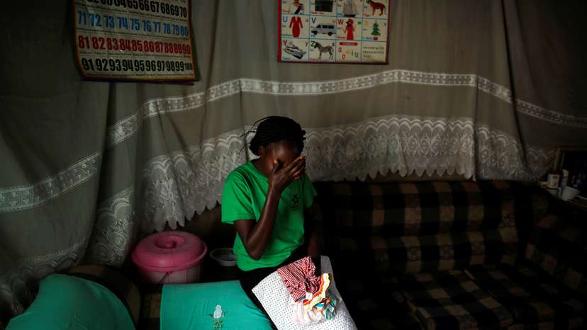 Lenzer Achieng, the mother of six-month-old Samantha Pendo who died during an August 2017 police crackdown on opposition supporters, holds her daughter's clothes inside her home, in the western city of Kisumu