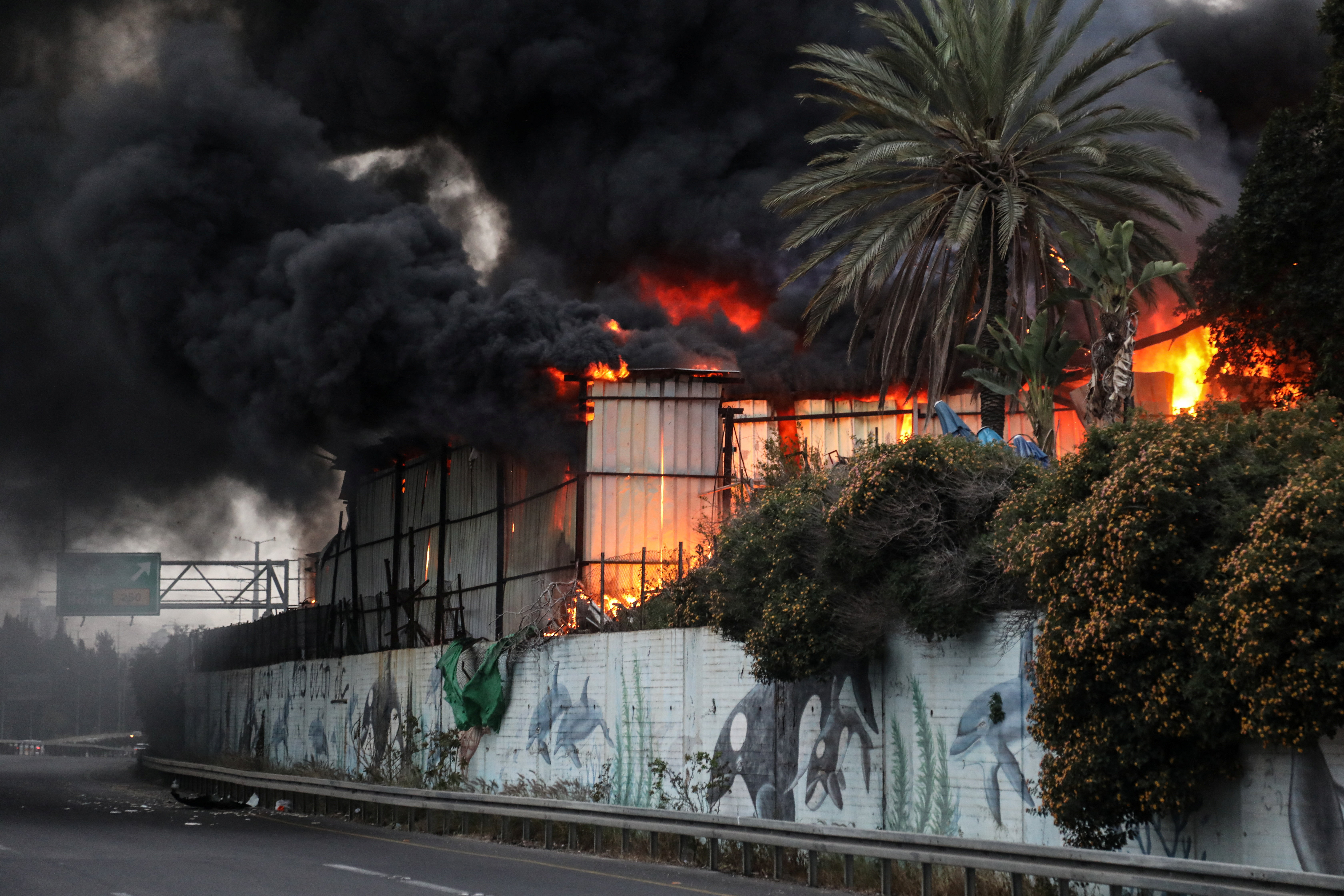 Fire ignited at the impact site following an Iranian missile strike, amid the U.S.-Israeli conflict with Iran, in central Israel