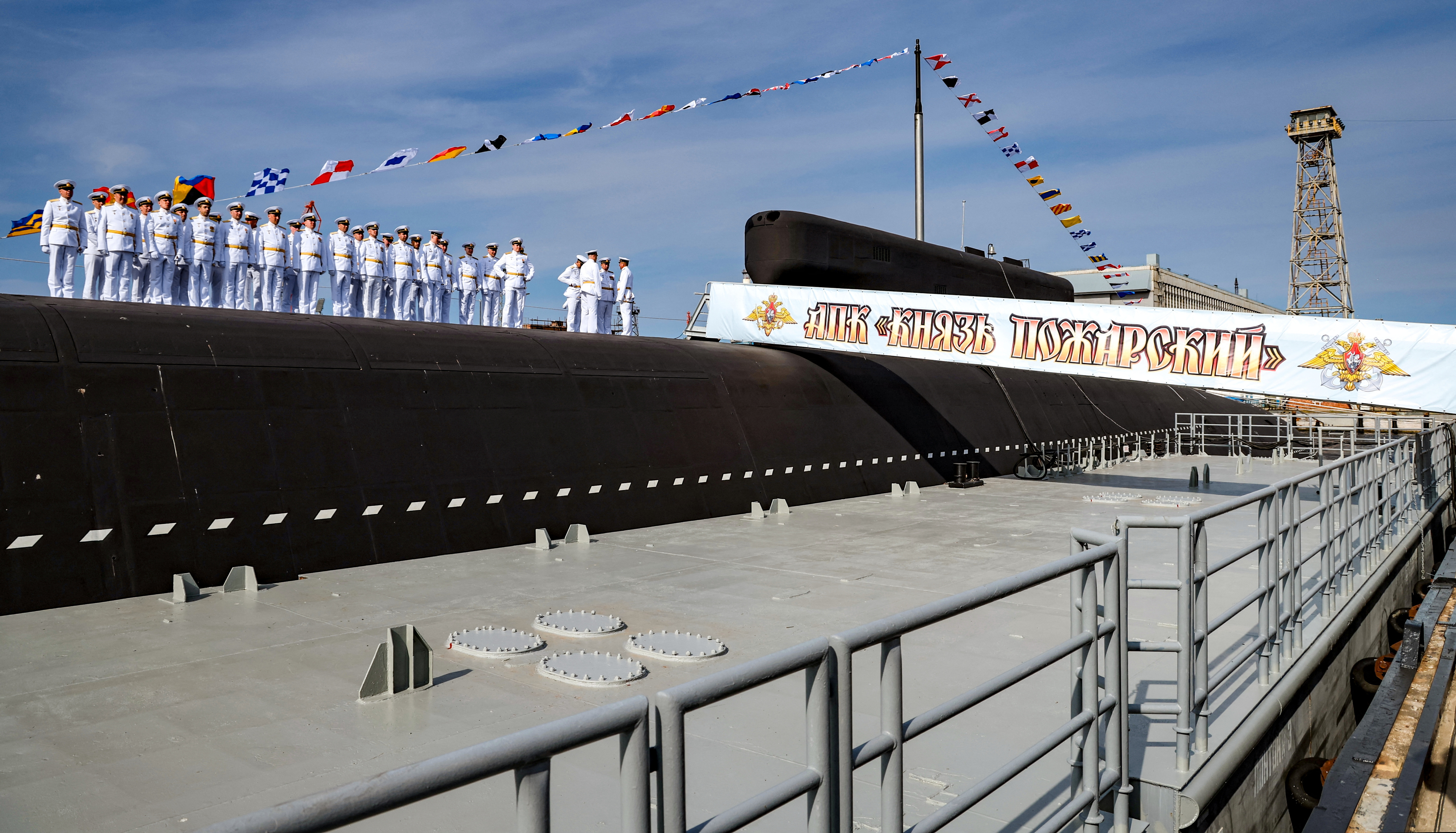 Crew members line up during a ceremony of raising a naval flag aboard the Knyaz Pozharsky nuclear-powered ballistic missile submarine in Severodvinsk