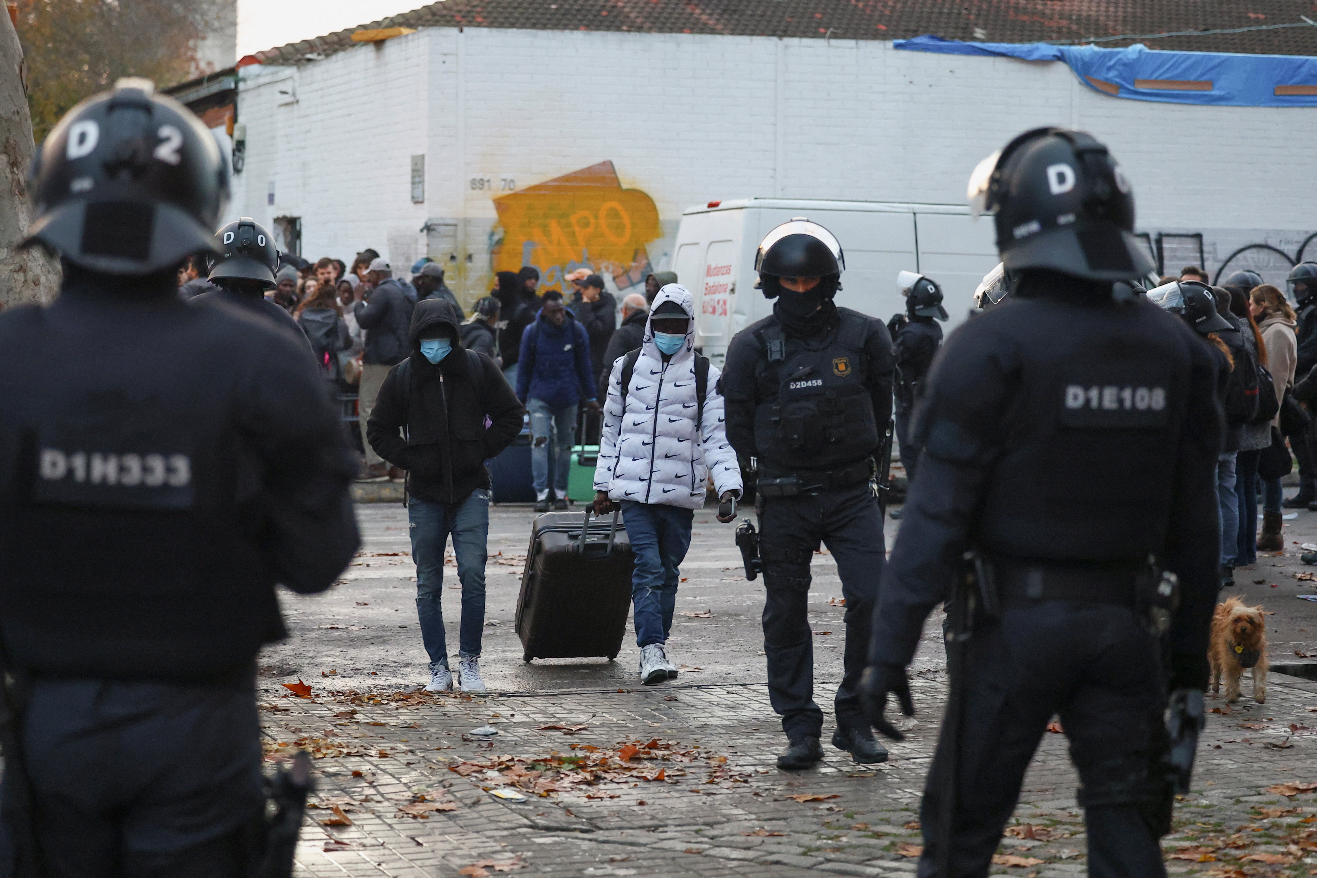 Police officers evict migrants from a former school in Badalona