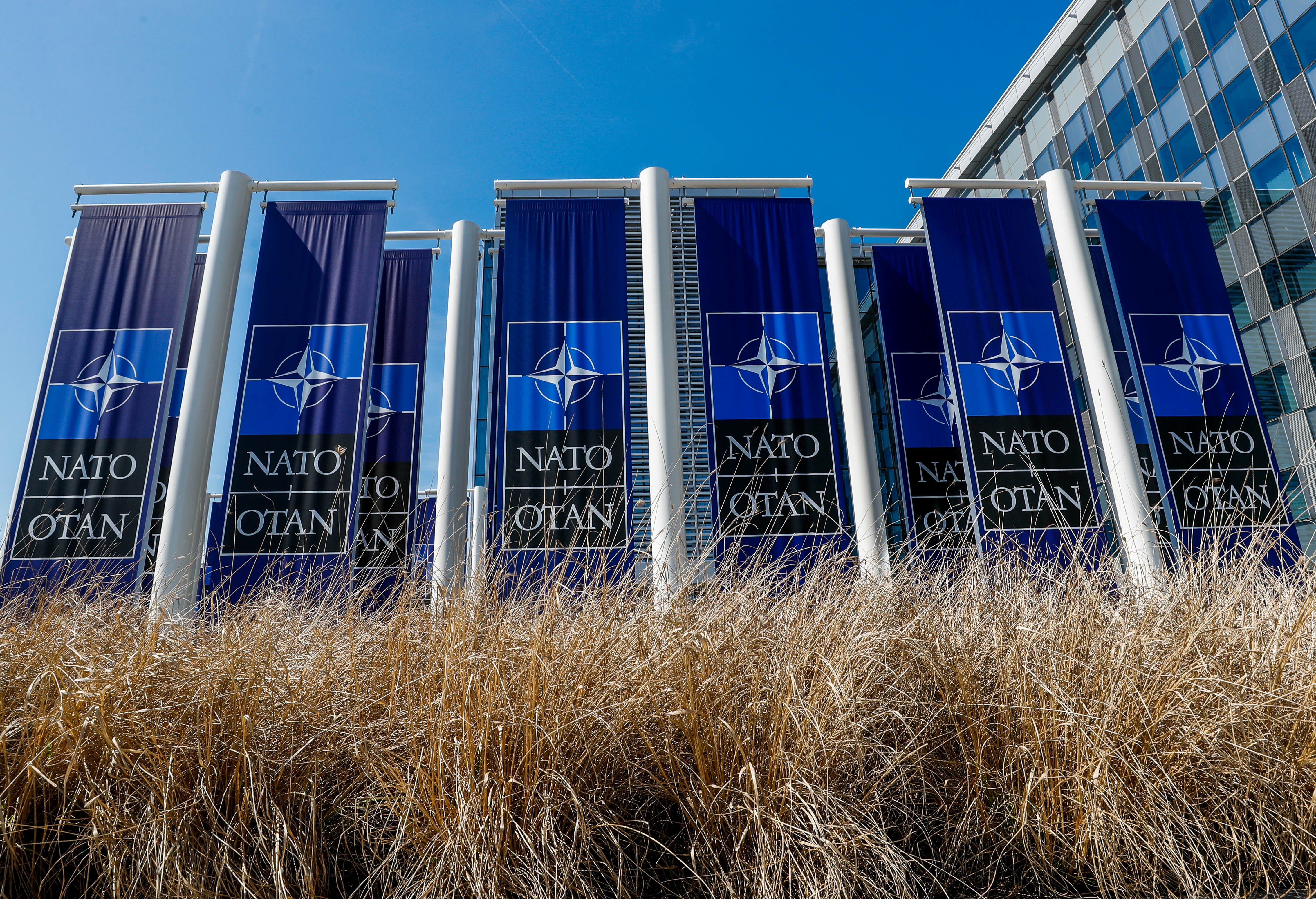 Banners displaying the NATO logo are placed at the entrance of new NATO headquarters during the move to the new building