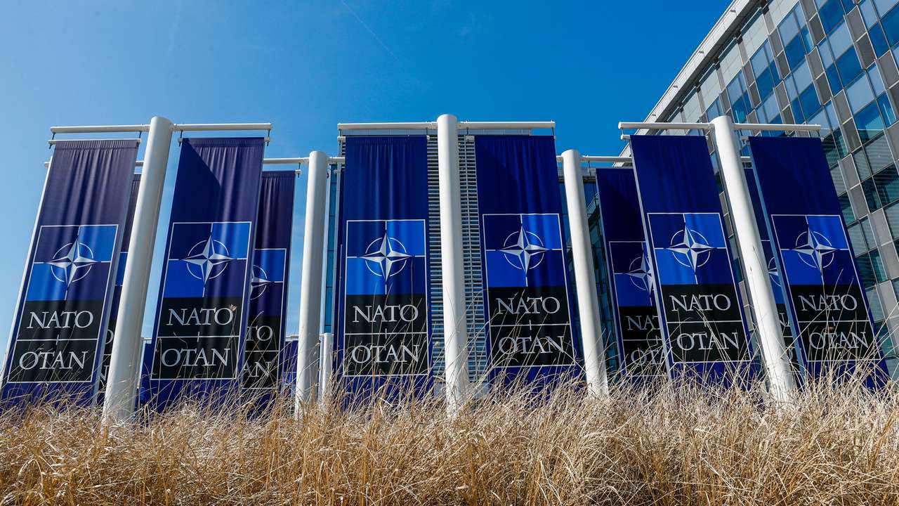 Banners displaying the NATO logo are placed at the entrance of new NATO headquarters during the move to the new building