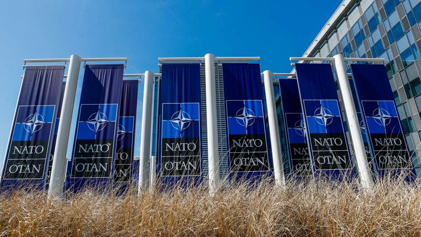 Banners displaying the NATO logo are placed at the entrance of new NATO headquarters during the move to the new building
