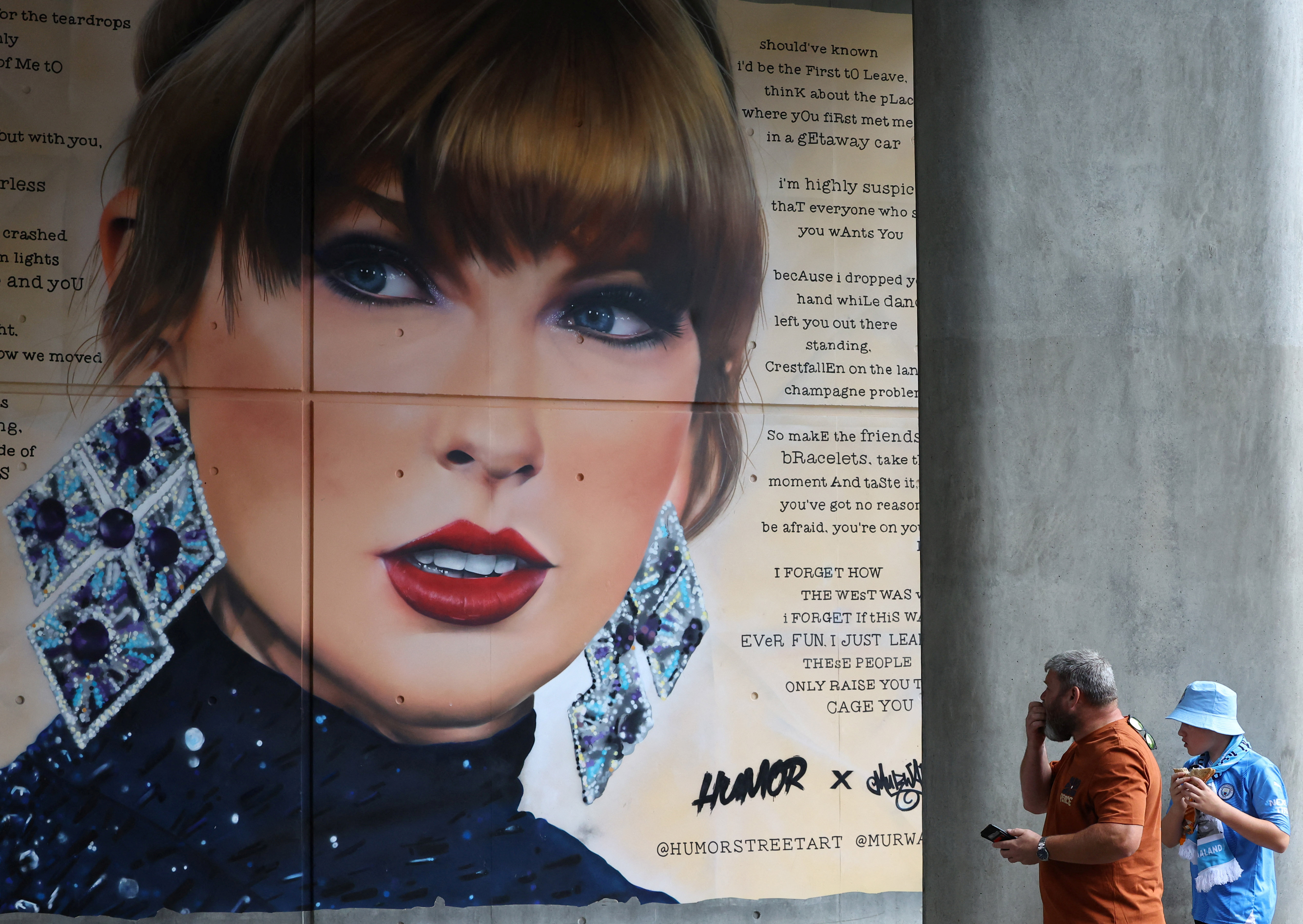 People view mural of Taylor Swift next to Wembley Stadium, as they attend Community Shield football match, at Wembley Stadium in London