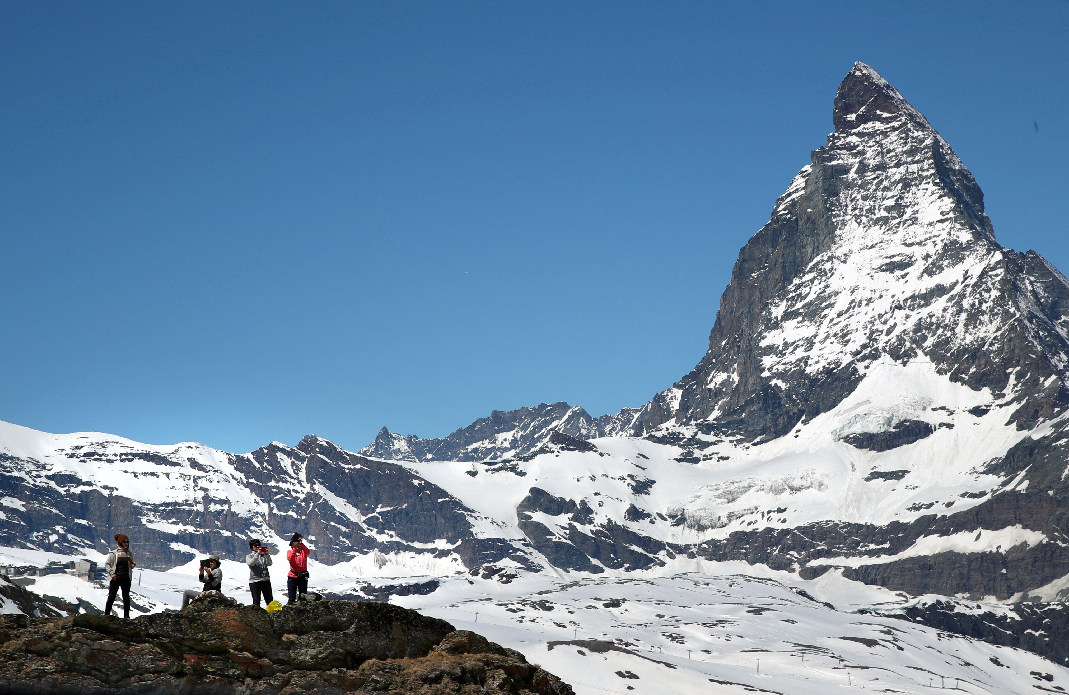 FILE PHOTO: Tourists take a picture in front of the Matterhorn mountain at the Gornergrat in Zermatt