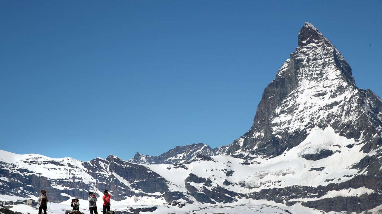 FILE PHOTO: Tourists take a picture in front of the Matterhorn mountain at the Gornergrat in Zermatt