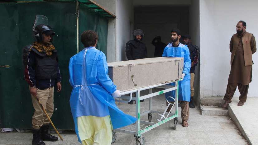 Paramedic staff move a coffin box, after gunmen shot and killed nine men after abducting them from a Iran-bound bus in Noshki district, at a hospital in Quetta