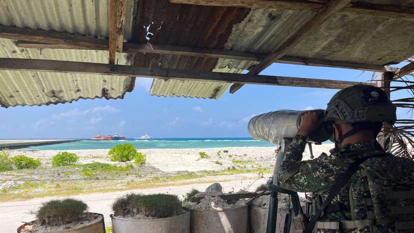 A Philippine soldier peers through an observation telescope from a viewing deck in Philippine-occupied Thitu Island in the disputed South China Sea