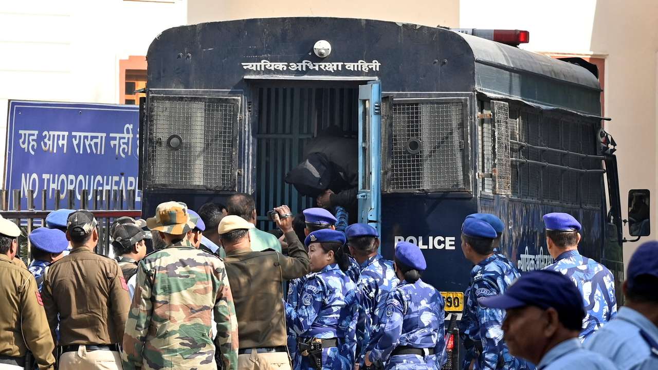 Amir Rashid Ali, a resident of Pampore in Indian Kashmir, is escorted by police after he was arrested by NIA, in New Delhi