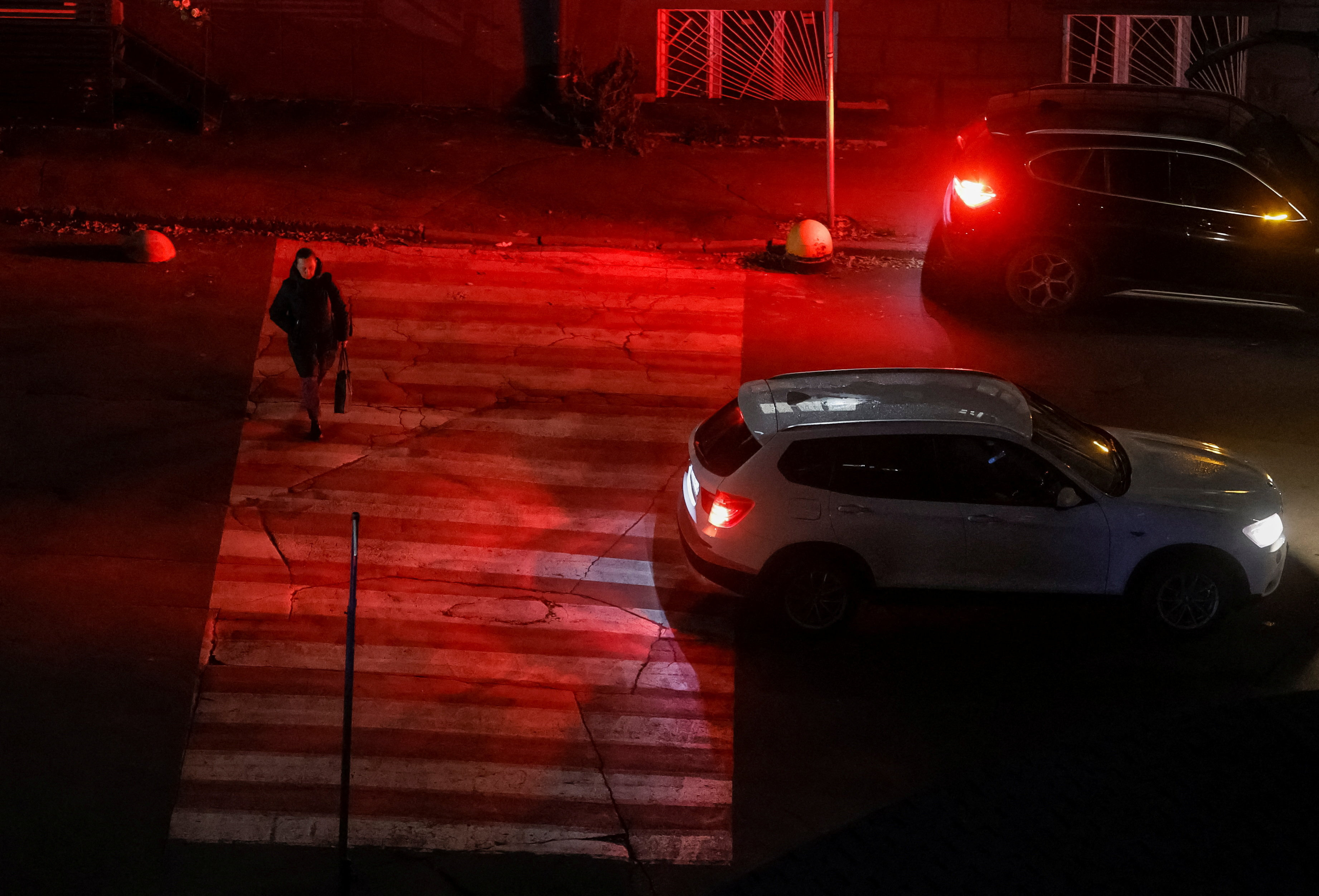 A woman crosses a street during a power blackout in Kyiv