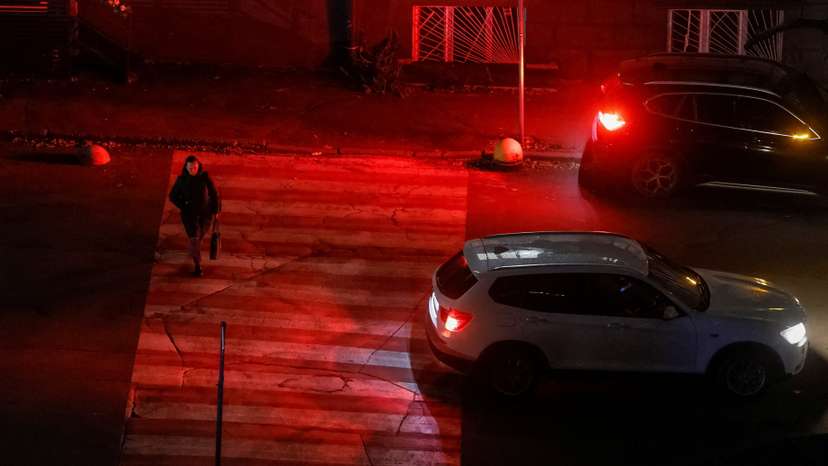 A woman crosses a street during a power blackout in Kyiv