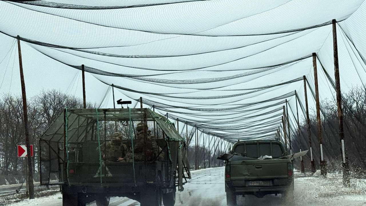 Ukrainian servicemen ride in a vehicle on a road covered with anti-drone net, in the frontline town of Kostiantynivka