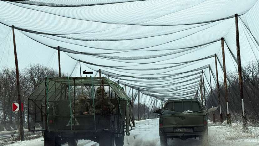 Ukrainian servicemen ride in a vehicle on a road covered with anti-drone net, in the frontline town of Kostiantynivka