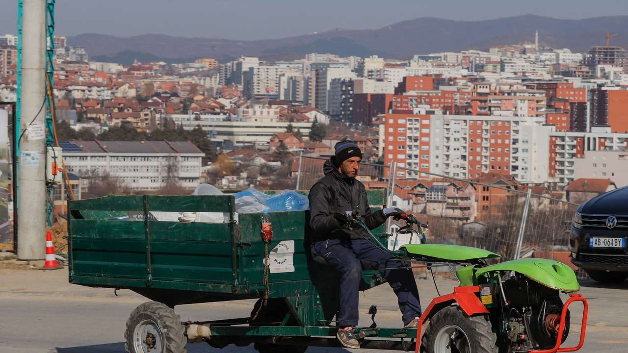Qazim Grashtica, recycling worker, drives his tractor searching for plastic, in Pristina