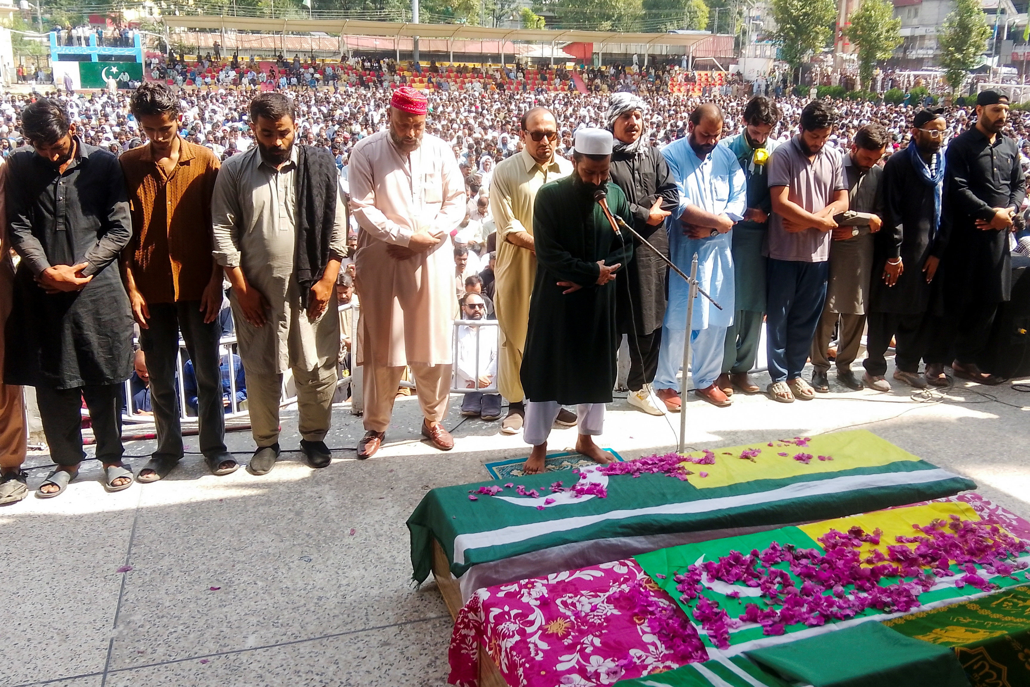 People attend the funeral of men, who were killed during a protest following a shutter-down strike in Muzaffarabad
