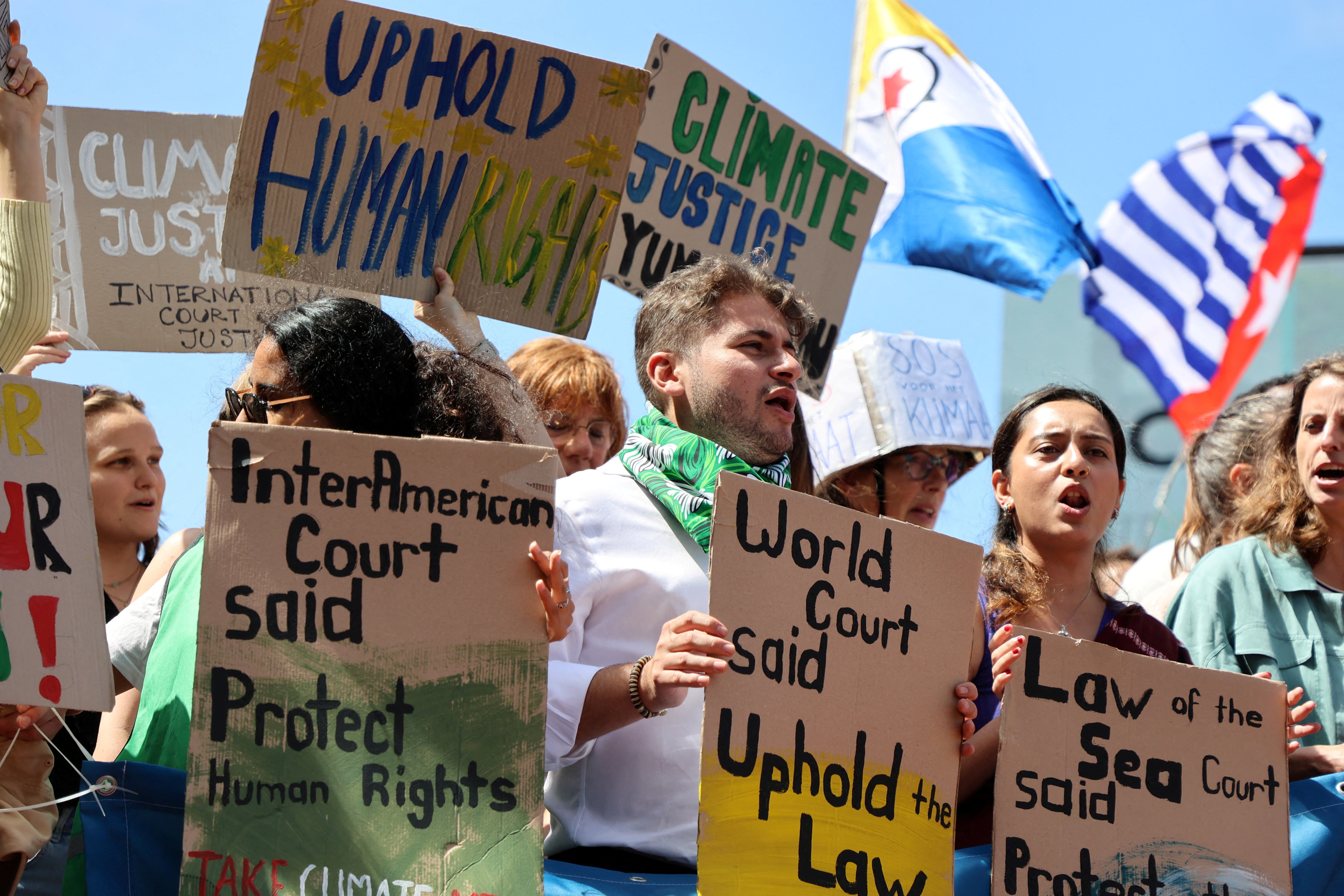 Climate activists and campaigners demonstrate outside the International Court of Justice (ICJ) in The Hague
