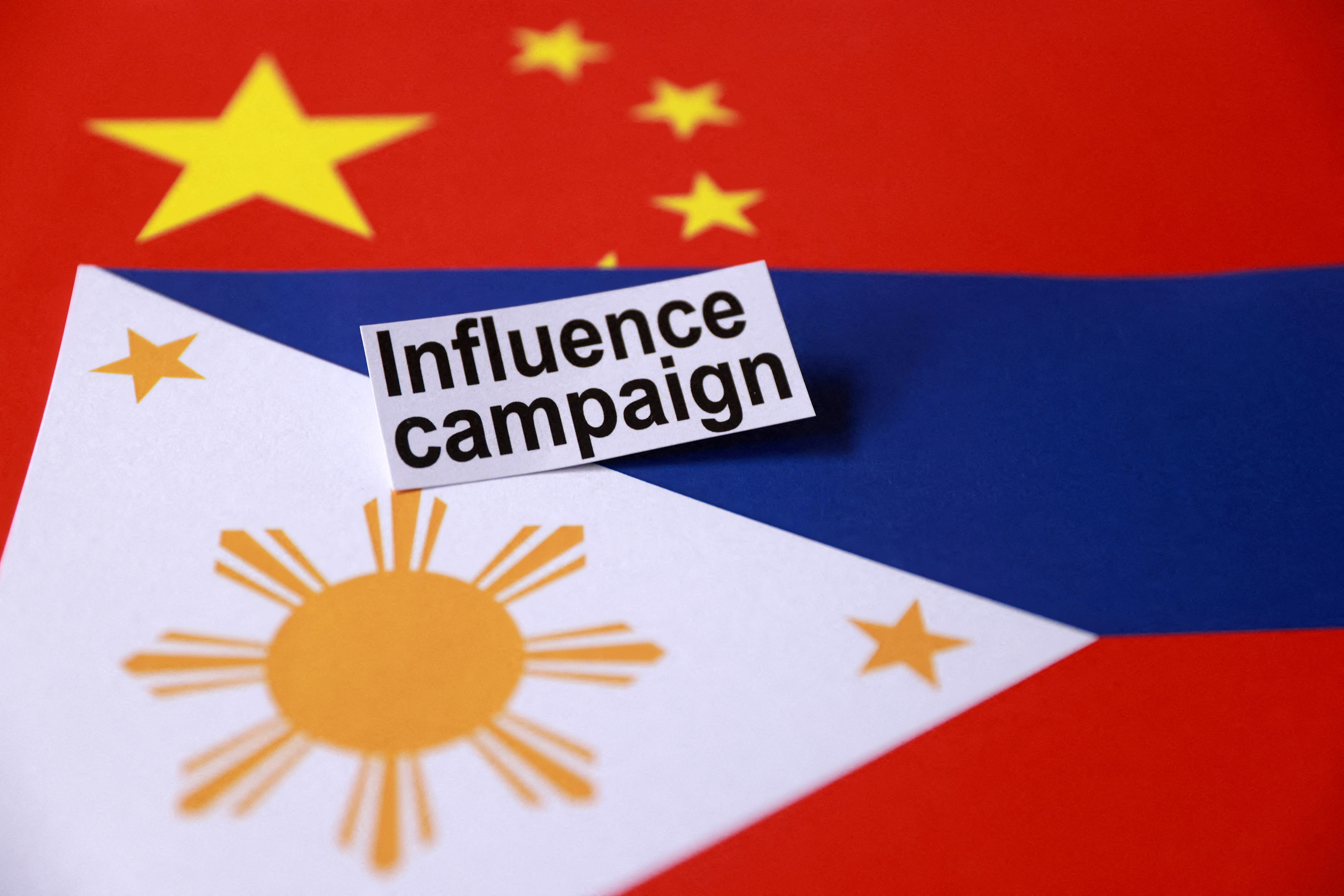 FILE PHOTO: Illustration shows a sign reading "Influence campaign" and Chinese and Philippines flags