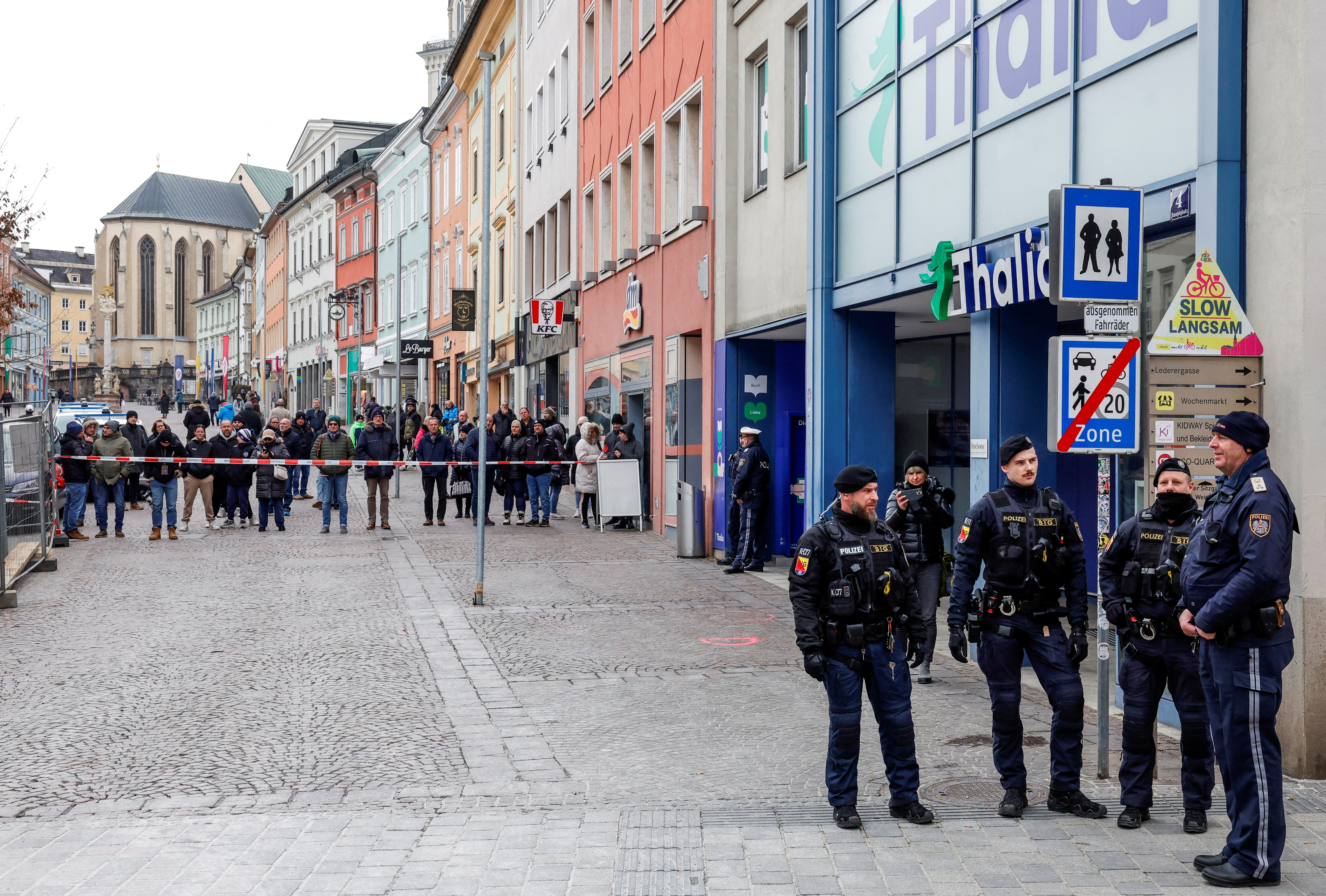 FILE PHOTO: Police officers stand guard at the scene where a 14-year-old boy was killed and several others were wounded in a stabbing attack, in the town of Villach