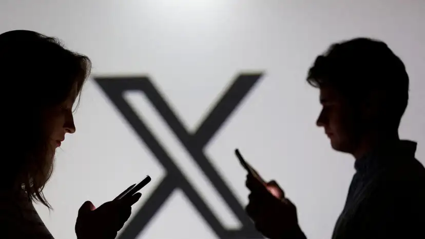 FILE PHOTO: Illustration shows teenagers pose for a photo while holding smartphones in front of a X logo